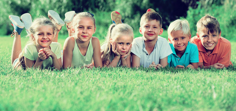 kids lying on green grass