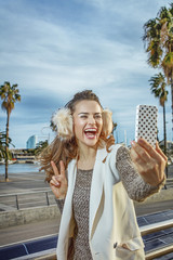 Fototapeta na wymiar happy woman in Barcelona, Spain taking selfie with smartphone