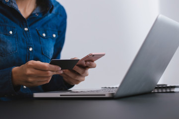 Woman shopping online using mobile phone and credit card