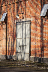 red brick wall and wooden door with vintage lamp