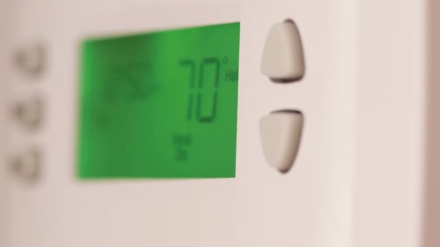 Digital thermostat used for heating and cooling - Energy expense and finance concept