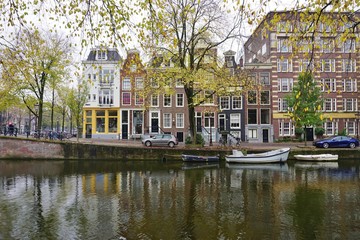 Traditional Dutch row houses and house boats along canals in Amsterdam