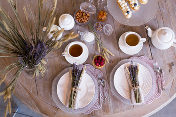 Table setting. Morning Breakfast with tea and cakes decorated with wheat and lavender