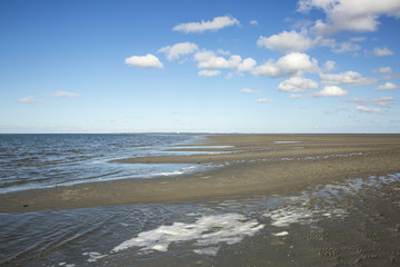 Maritime landscape with reflection of clouds in low tide water, Waddenzee, Friesland, The Netherlands