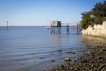 Fototapeta na wymiar traditional fisherman's wooden hut at the bottom of the limestone cliff in the estuary of Gironde, Talmont