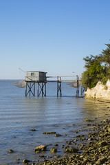 Fototapeta na wymiar traditional fisherman's wooden hut at the bottom of the limestone cliff in the estuary of Gironde, Talmont