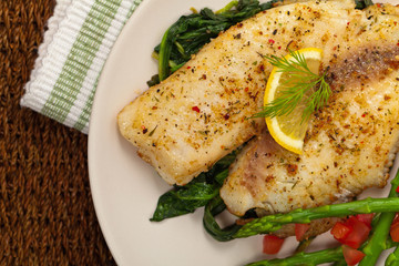 Baked Fish Fillet with Sauteed Spinach. Selective focus.