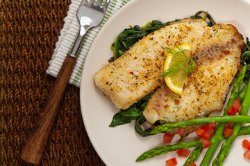 Baked Fish Fillet with Sauteed Spinach. Selective focus.