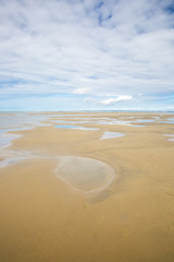 maritime seaside landscape with water, sand bank and white cloud, garonne estuary near Royan, France