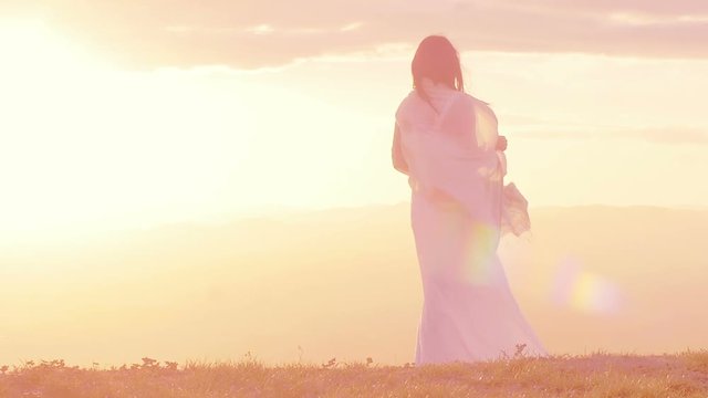 beautiful woman at the sunset on the top of a mountain:sunset with lens flare