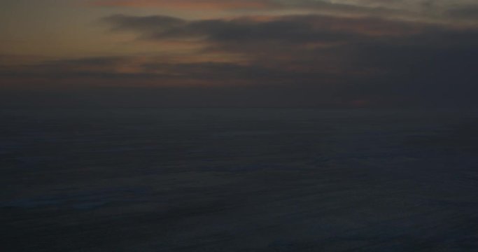 Clouds darken frozen tundra after sunset
