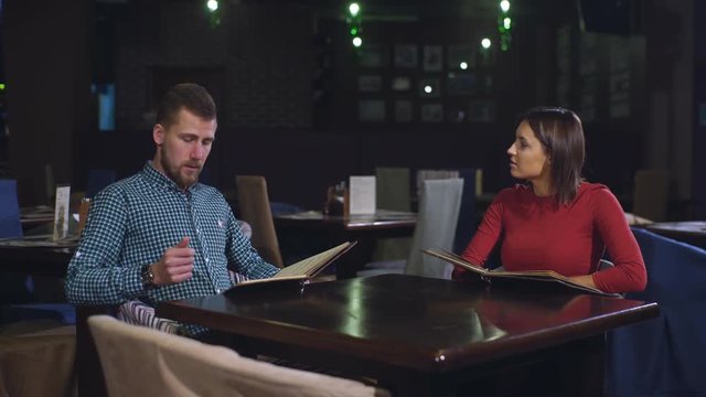 Cheerful couple with menu in a restaurant