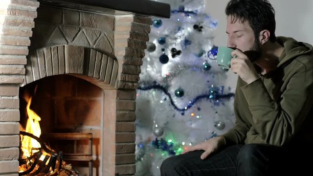 portrait of sad man in pensive attitude sat near a fire, home scene