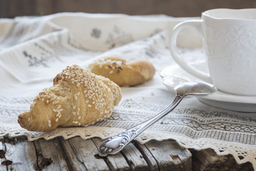 Porcelain cup and saucer and cakes on a wooden old table. Rustic.