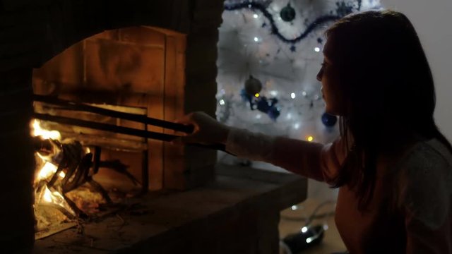 woman managing with a fire hook with a burning fire, christmas time