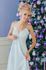 portrait of a luxurious blonde in a white dress at the Christmas