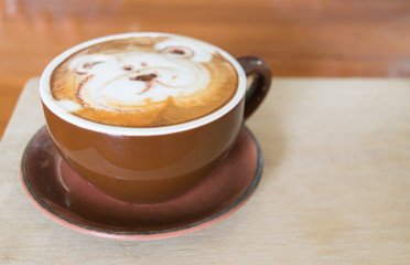 Close up white cup of Coffee with bear hand drawn on top, Coffee latte on the wooden.