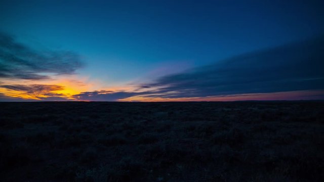 Timelapse brilliant color on sunrise clouds over sagebrush prairie