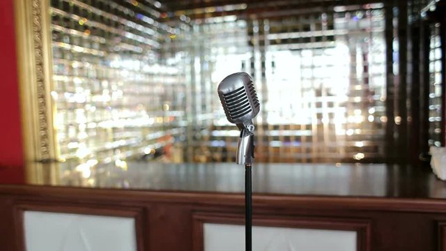 Old microphone on a shimmering background. Retro microphone. The microphone in the karaoke bar.