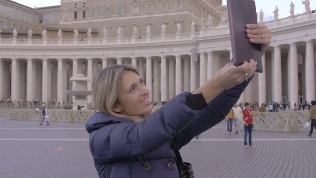 cute woman using tablet computer to make photos to St. Peter Cathedral in Rome