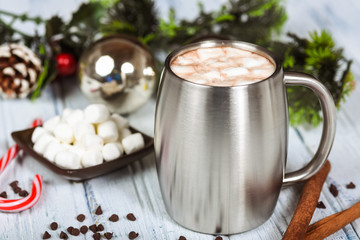 Hot chocolate in stainless steel cup with Christmas decorations