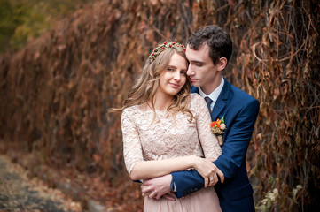 Fototapeta premium Portrait of happy newlyweds in autumn nature. Happy bride and gr