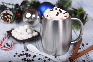 Hot chocolate with whipped topping in stainless cup and Christma
