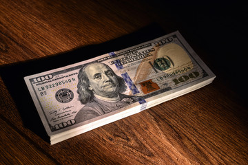 Stack of American dollars lie on wooden boards