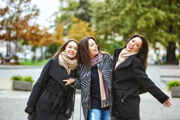 Three young cute girls having fun together on a city walk . A way of life .