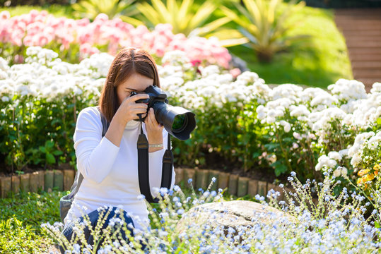 Female photographer taking pictures of flowers