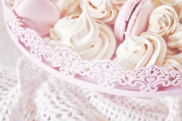 Retro toned homemade pink and white meringues on a plate
