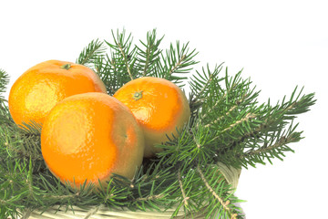Fototapeta na wymiar Three ripe juicy orange tangerines in the basket on the green tr