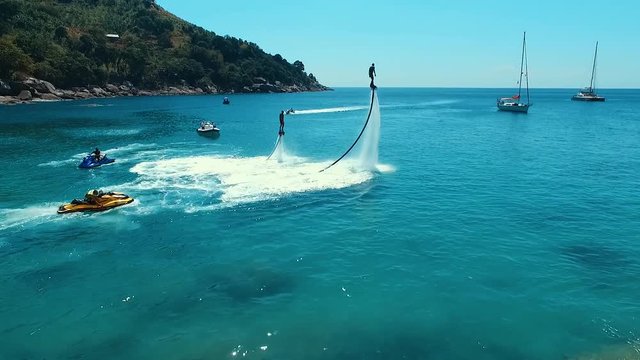 Aerial: Diving on flyboard near the beach.