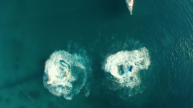 Aerial: Two men flyboarding near the boat.