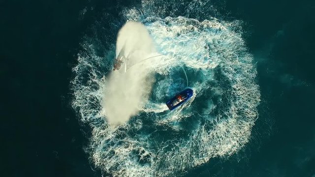 Aerial: Two men flying on flyboard near the boat.