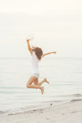 Asian young lady jumping on the beach with fun and happiness