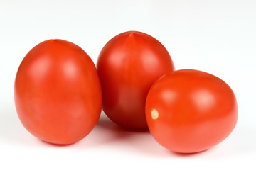 Three red ripe tomato close up on a white background.