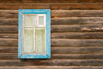 Window with blue wooden frame in an old log house