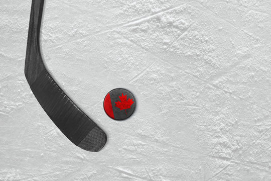 Canadian hockey stick and puck on the ice hockey rink