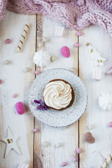 Fototapeta na wymiar Christmas candy background. Cupcake with cream on plate, flat l