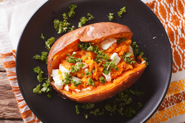 great food: sweet potatoes baked with cream cheese, butter and parsley close-up. horizontal top view