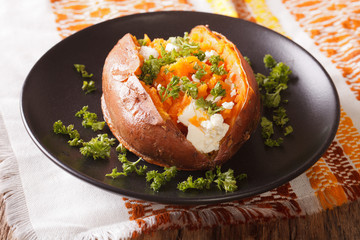 great food: sweet potatoes baked with cream cheese, butter and parsley close-up. horizontal
