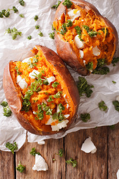 Delicious baked sweet potatoes stuffed with feta cheese and parsley close-up. vertical top view