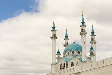 Fototapeta na wymiar Beautiful white mosque with blue roof against the sky with clouds