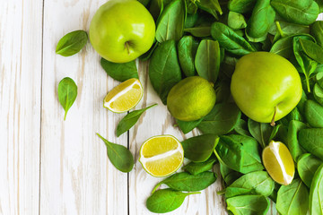 Wooden backgroung with healthy green spinach, lime and apple