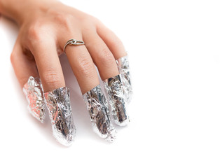 Removal of gel nail polish using a foil. Isolated on white.