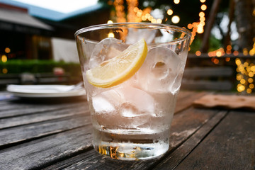 Lime or lemon and ice in transparent glass wait for drink to fil
