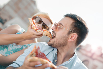 Pizza time. Couple eating pizza outdoors