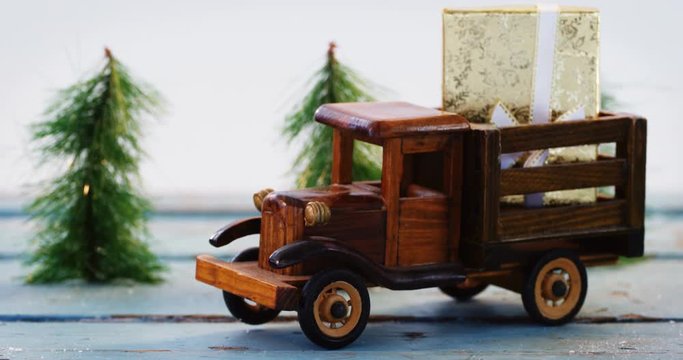 Toy tempo carrying christmas present on wooden plank