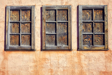 Old rustic three wooden window on orange wall background